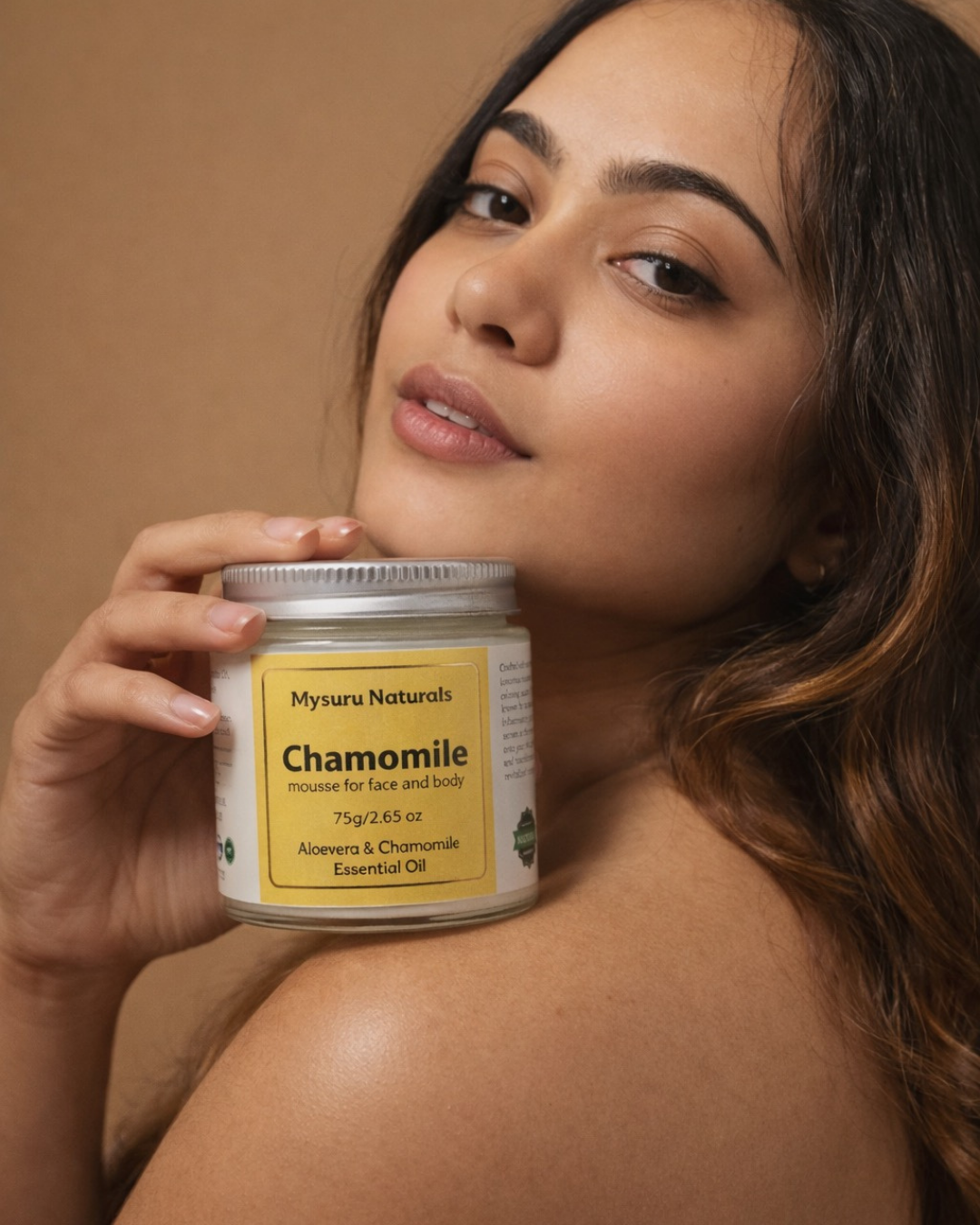 Woman holding a mysuru naturals chamomile product against a brown background
