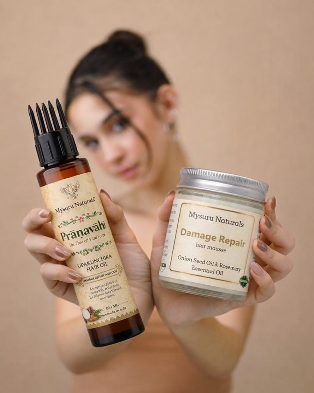 Person holding mysuru naturals pranavah and damage repair hair products against a beige background